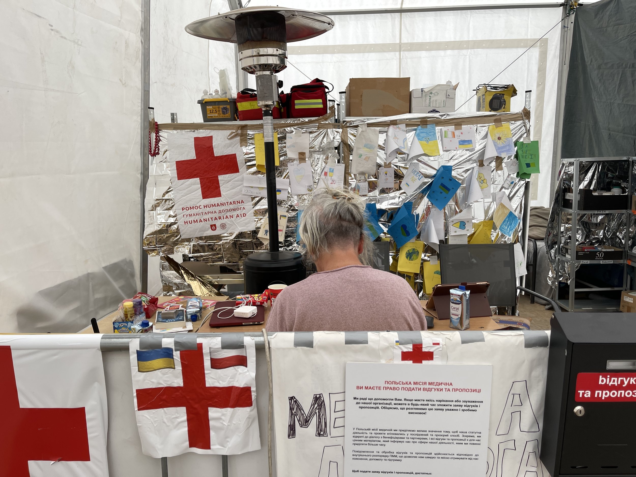 A humanitarian aid station with a table filled with various supplies like food, medicine, and personal care items inside a tent in Ukraine during the Russian Ukraine war from the United Nations